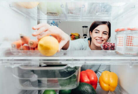 Trucchi mentali per perdere peso: donna che prende un limone dal frigorifero.
