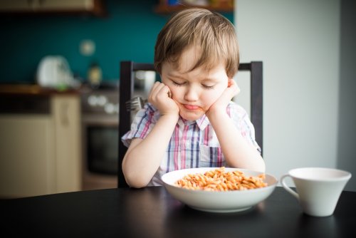 Il bambino non vuole mangiare: bambino che rifiuta un piatto di pasta.