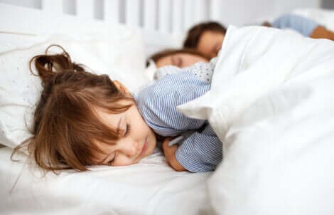 Bambina che dorme con i genitori.