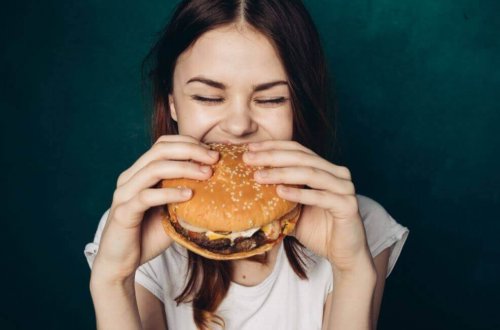 Donna che mangia hamburger