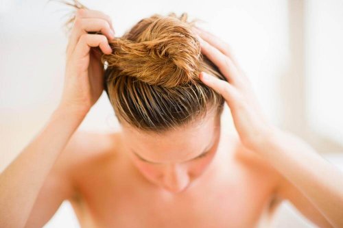 Ragazza bionda raccoglie sulla testa i capelli bagnati