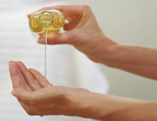 Olio di mandorla versato sulle mani per schiarirle
