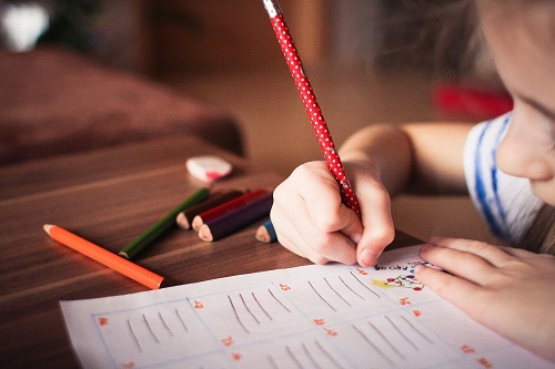 Mano di bambino che scrive su foglio