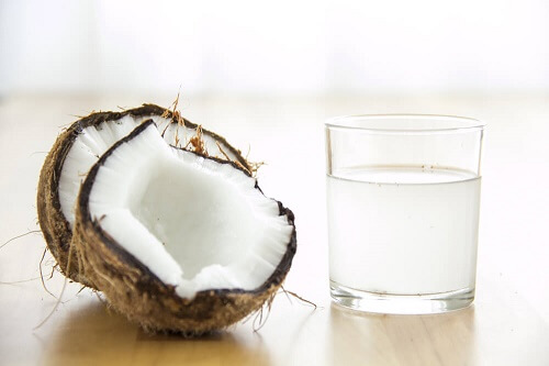 Due cocchi con bicchiere di acqua di cocco