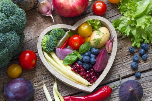 Un recipiente a cuore con frutti e verdure dentro