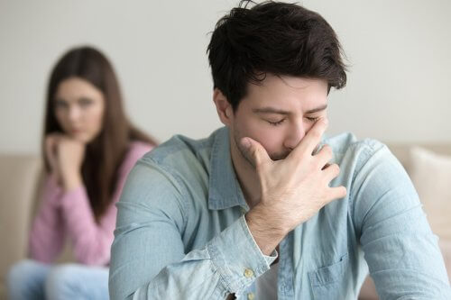 Ragazzo piange mentre ragazza triste lo guarda da dietro