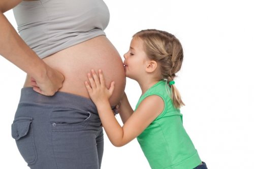 Bimba bacia la pancia della mamma