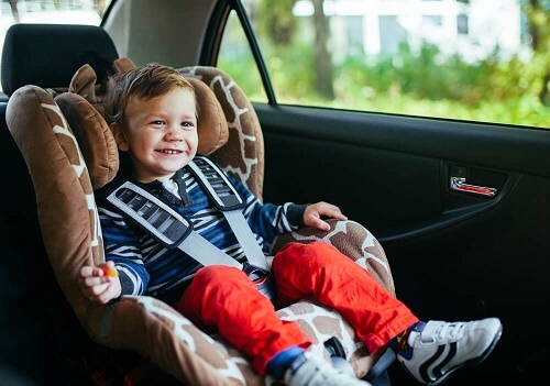 Bimbo sorridente seduto in seggiolino auto