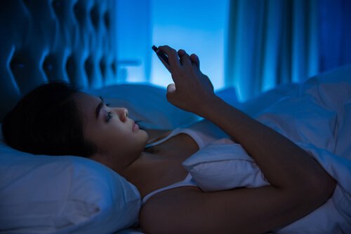 Giovane asiatica a letto legge messaggini