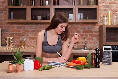 Ragazza scrive su tavola con prodotti naturali