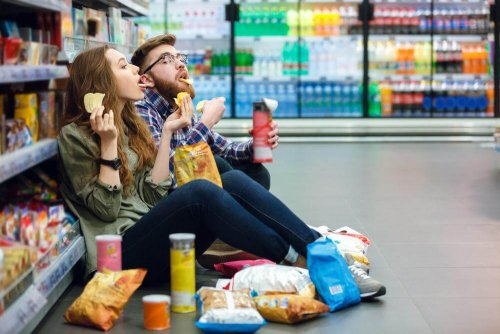 Ragazzi al supermercato mangiano patatine seduti per terra