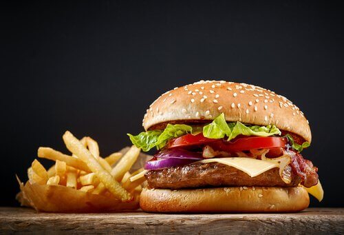 Un hamburger di pollo in panino con patate fritta e lato