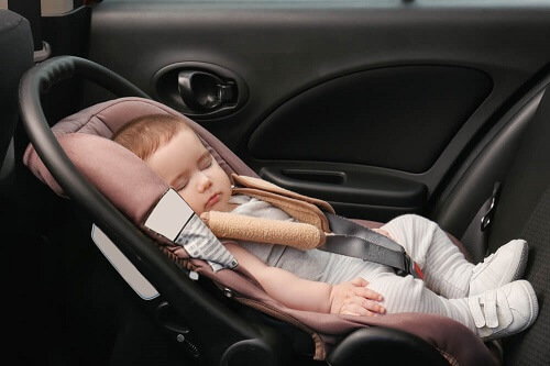 Un seggiolino auto montato davanti al contrario con bebe che dorme