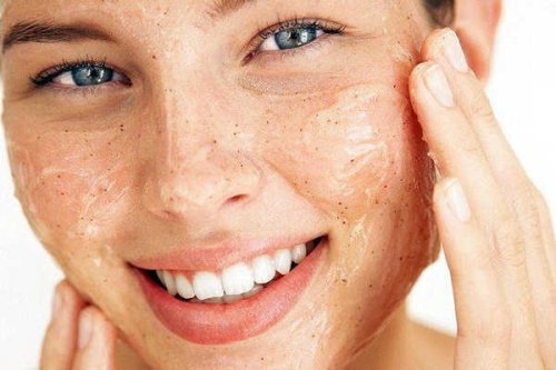Ragazza esfolia il viso per avere una pelle morbida e pulita