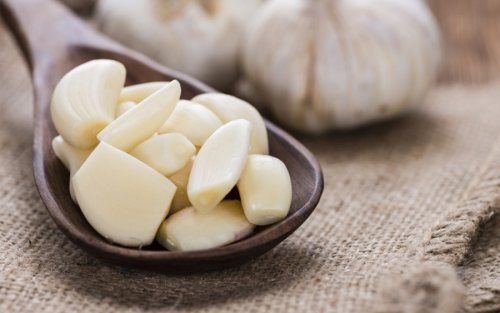 Spicchi di aglio in un cucchiaio di legno