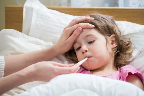 Bambina con febbre e termometro