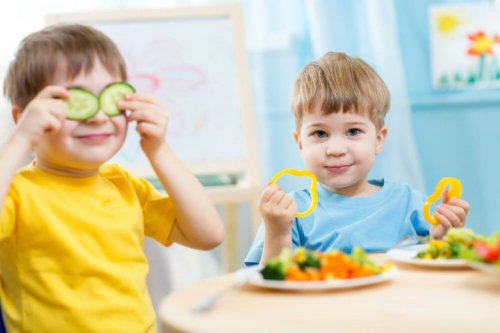 Bambini giocano a tavola mentre mangiano le verdure