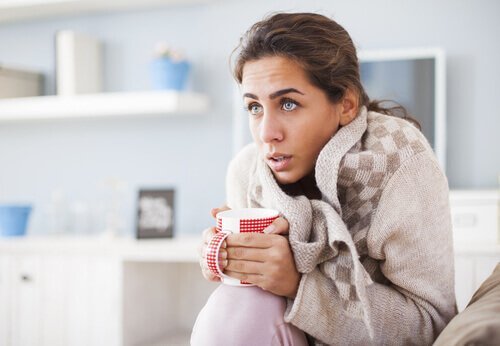 Donna infreddolita con tazza tra le mani