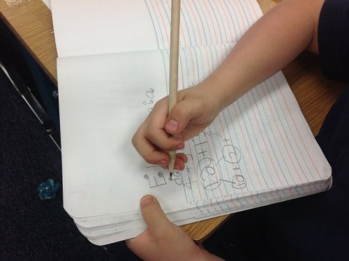 Bambino scrive su quaderno a righe 
