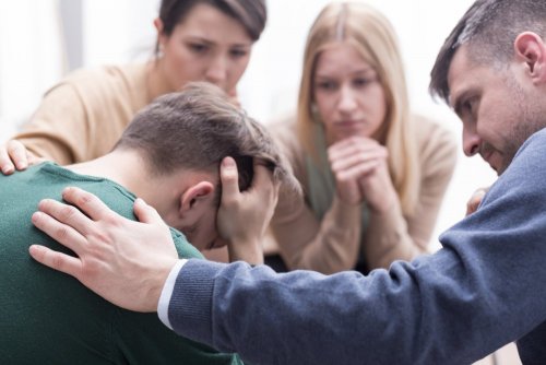 Uomo consolato dagli amici