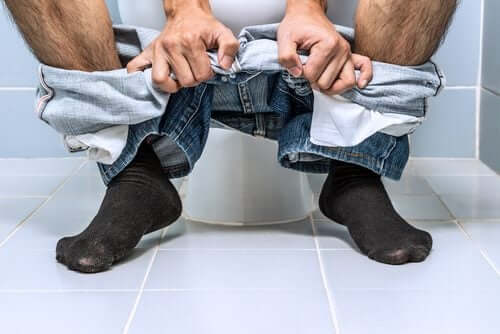 Uomo in bagno affetto da emorroidi.