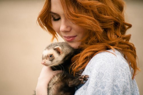 Donna che abbraccia un furetto