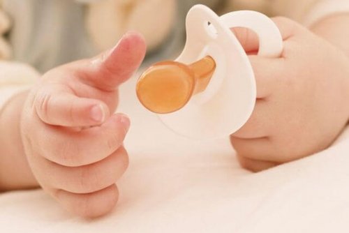 Mani di bambino con ciuccio