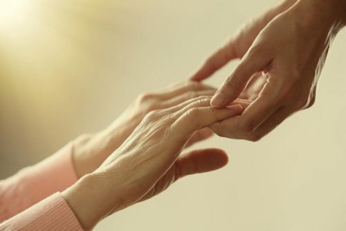 Mani di persona giovane toccano mani di donna anziana