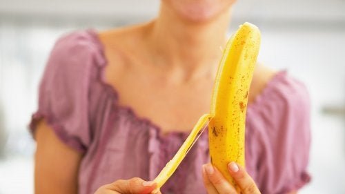 Ragazza sbuccia una banana