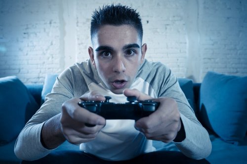 Adolescente che gioca alla playstation, relazione tra videogiochi e adolescenti