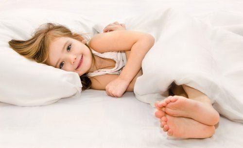 Bambina sorridente nel letto