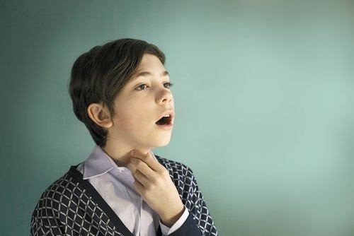 Bambino canta con la mano sulla gola