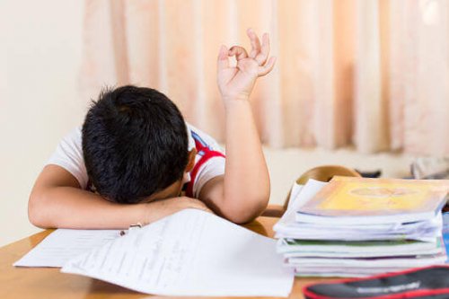 Bambino stanco sui libri di scuola