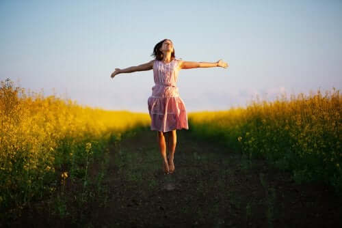 Ragazza con le braccia aperte in mezzo alla natura.