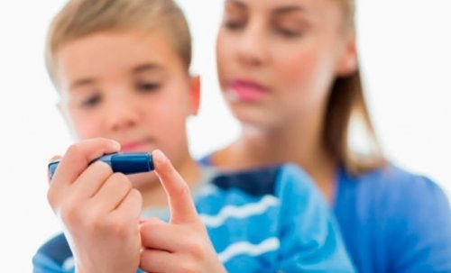 Madre e figlio con penna per la misurazione della glicemia