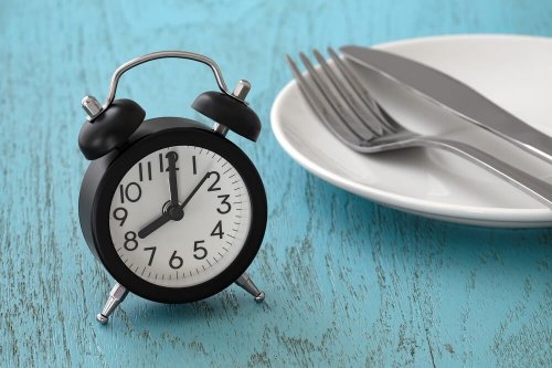 Benefici del digiuno intermittente: piatto, forchetta e sveglia