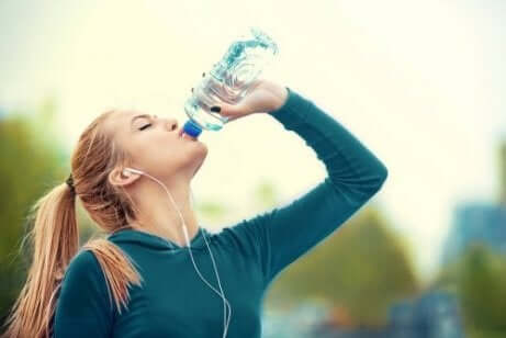 Ragazza che beve acqua mentre fa sport
