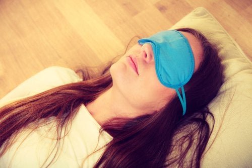 Ragazza con mascherina sugli occhi per dormire meglio