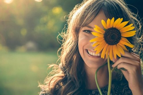 Donna felice con girasole sul viso