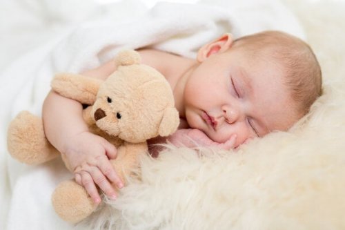 Neonato che dorme con un peluche