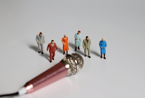 Microfono con persone in miniatura