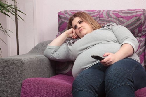 Donna obesa seduta sul divano
