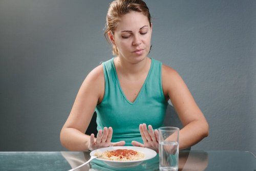 Donna che rifiuta un piatto di pasta