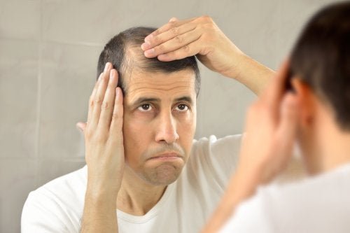 Uomo si controlla i capelli allo specchio