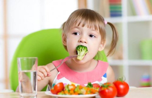 Bambina che mangia un broccolo