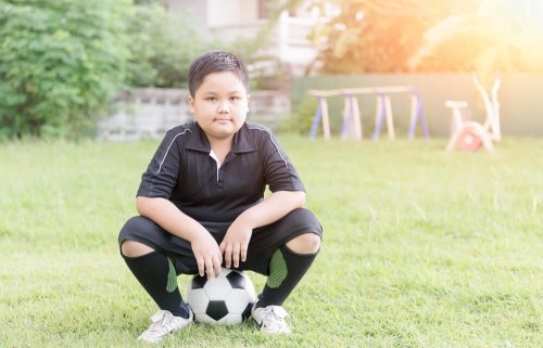 Bambino che fa calcio per combattere la obesità infantile