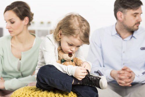 Bambino che si allaccia le scarpe e genitori distratti