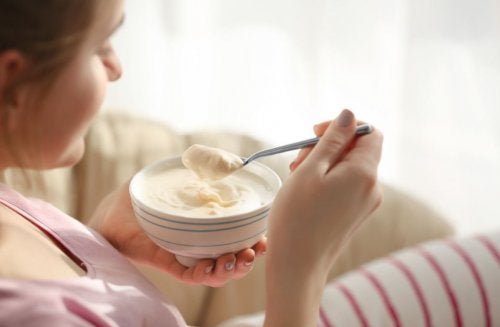 Ragazza che mangia lo yogurt