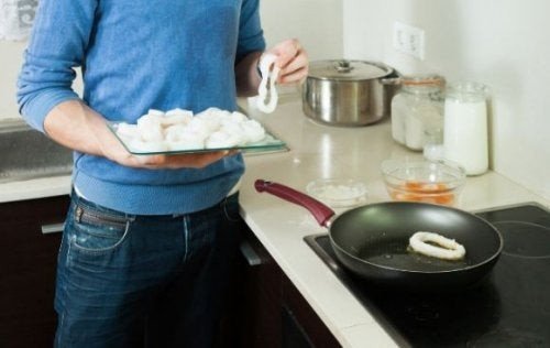 Uomo che cucina i calamari in umido