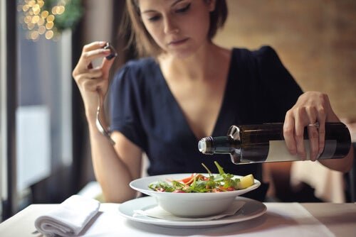 Donna condisce piatto di insalata